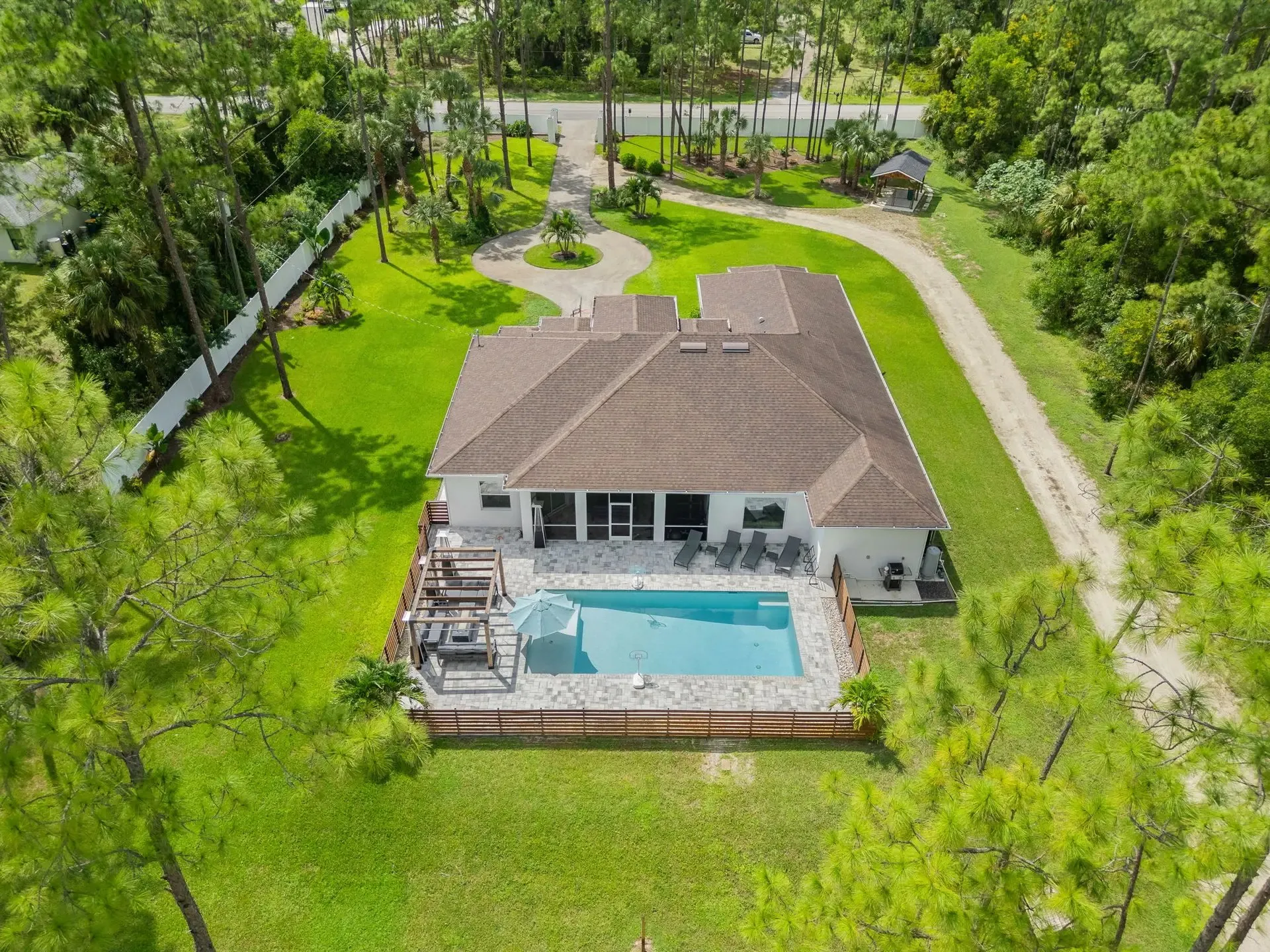 Drone photo of a pool home on a large wooded lot