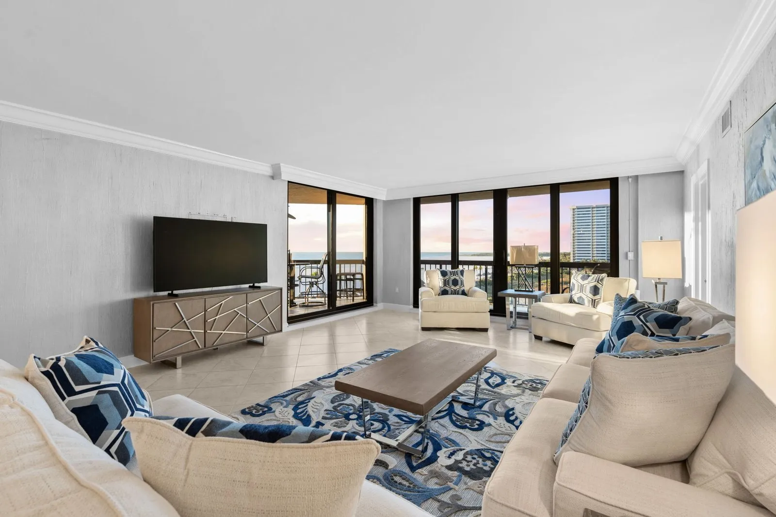 Condo living room with floor-to-ceiling windows and ocean views