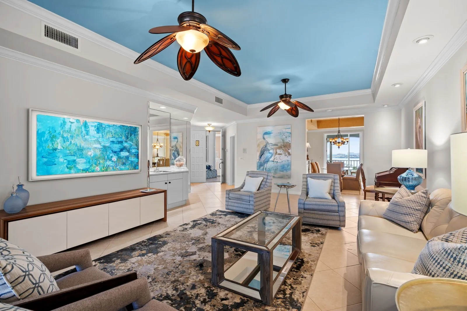 Living room with ceiling fans and water views