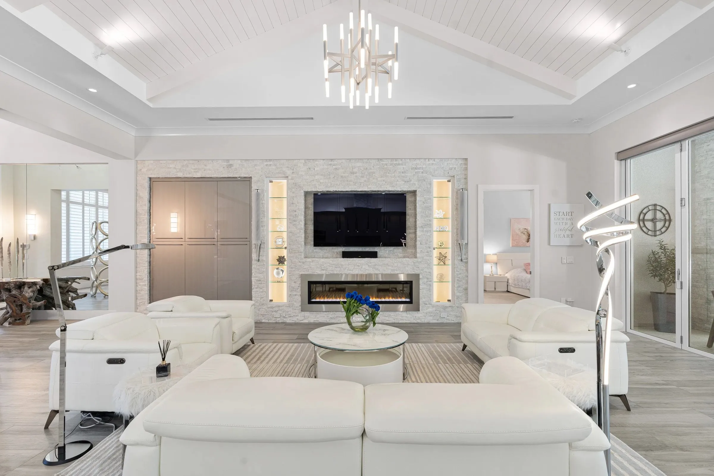Living room with a crystal chandelier and TV wall
