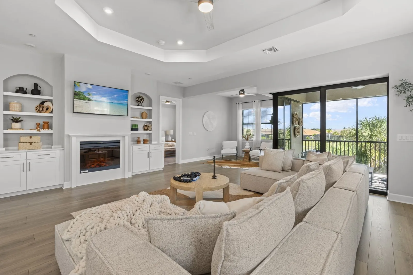 Living room with a fireplace, built-in shelving and a tray ceiling