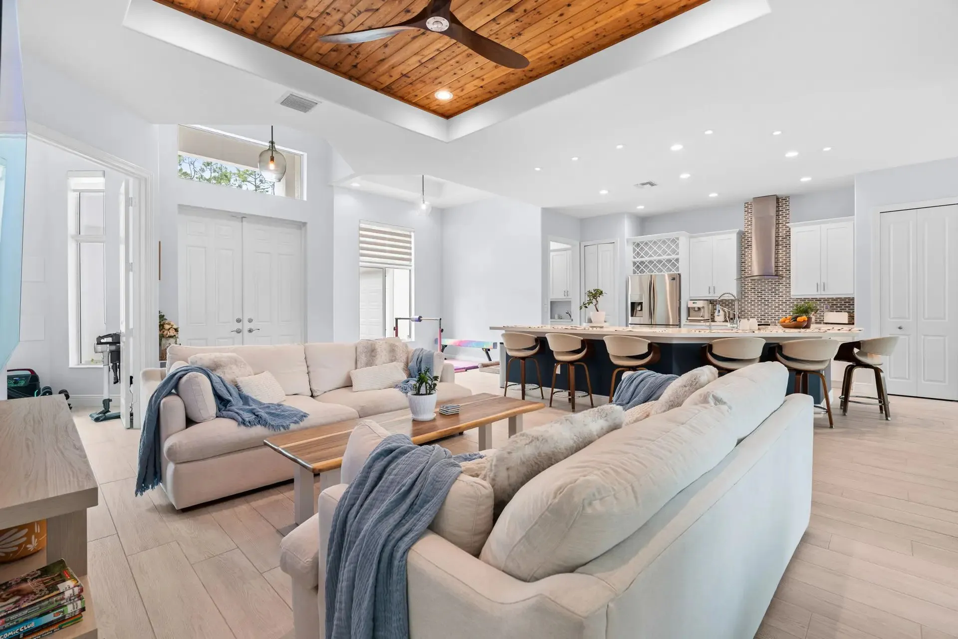 Living room with a wood plank ceiling and open dining area