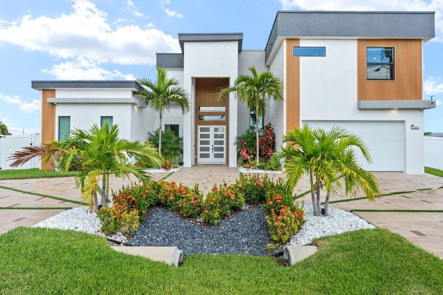 Modern two-story home with wood accents and tropical landscaping