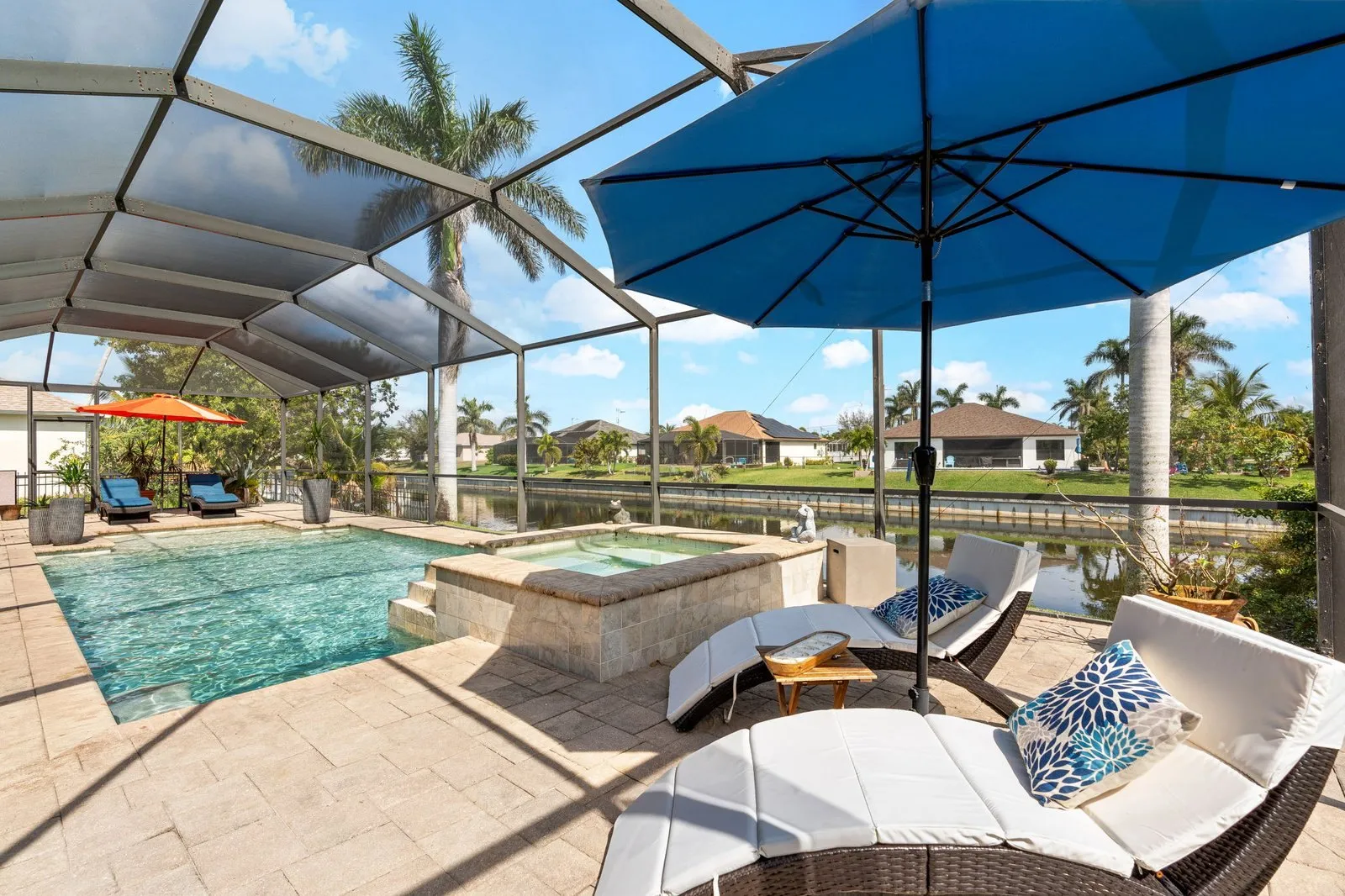 Pool deck with umbrellas and a screened lanai