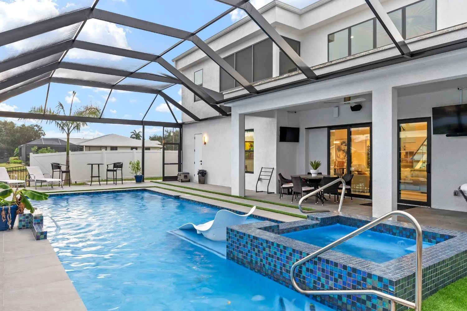 Pool and spa under a screened lanai with water views