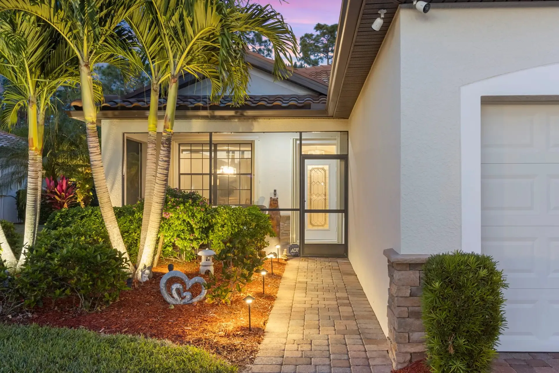 Home entry at twilight with landscape lighting