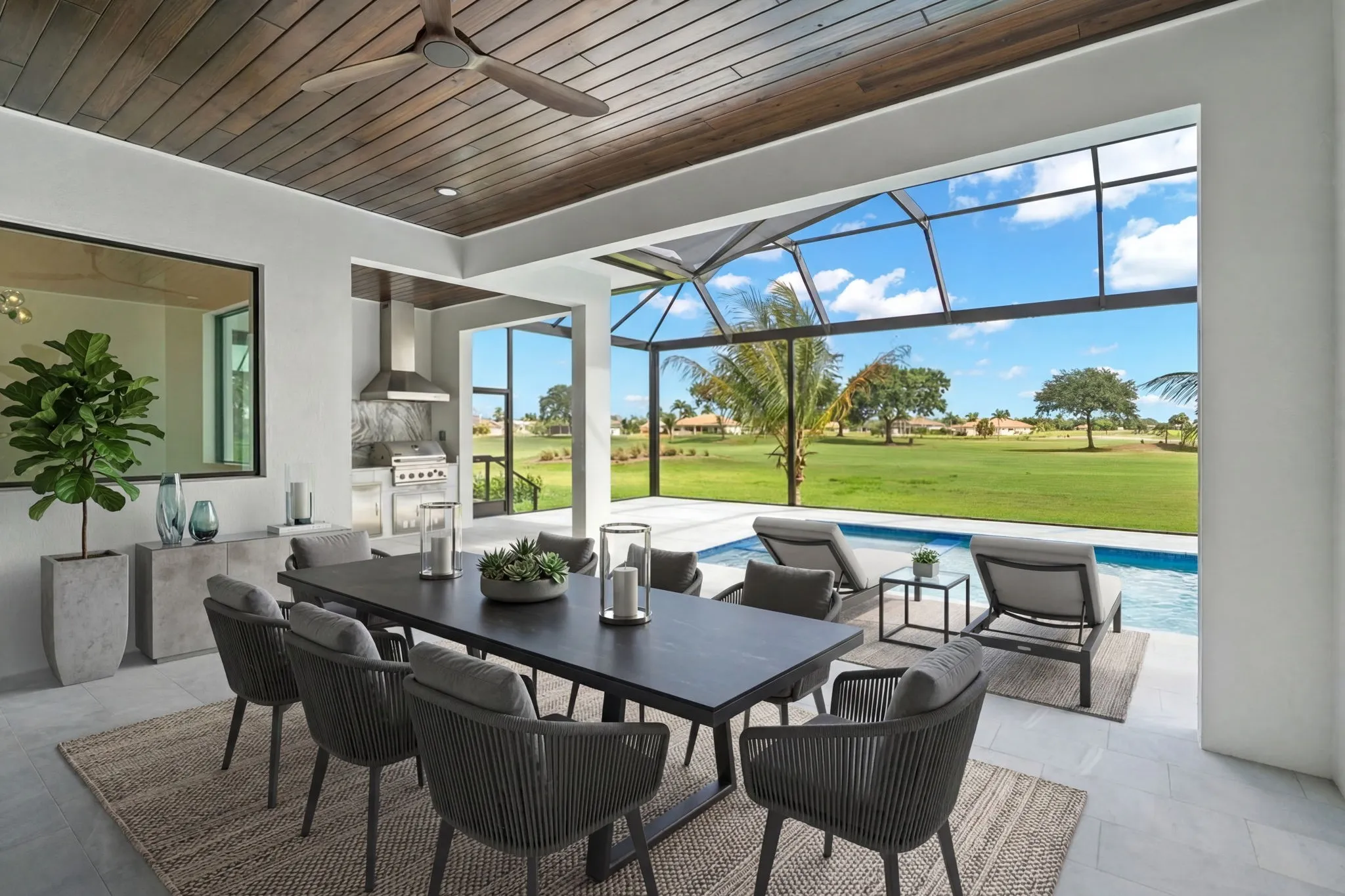 The same lanai virtually staged with an outdoor dining table and pool loungers