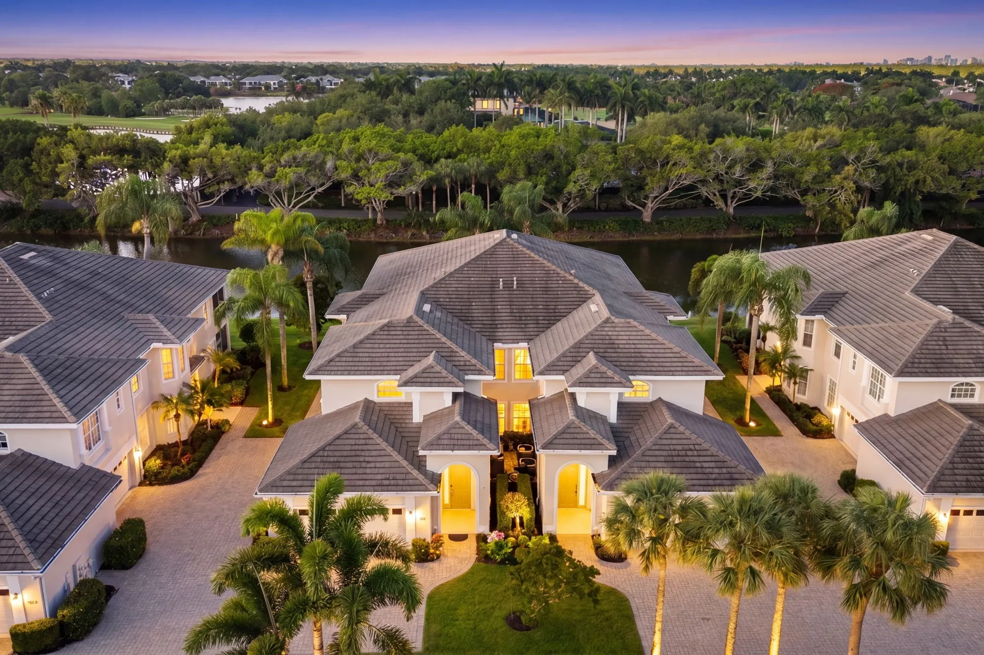 The same drone view edited into a twilight scene with the homes lit