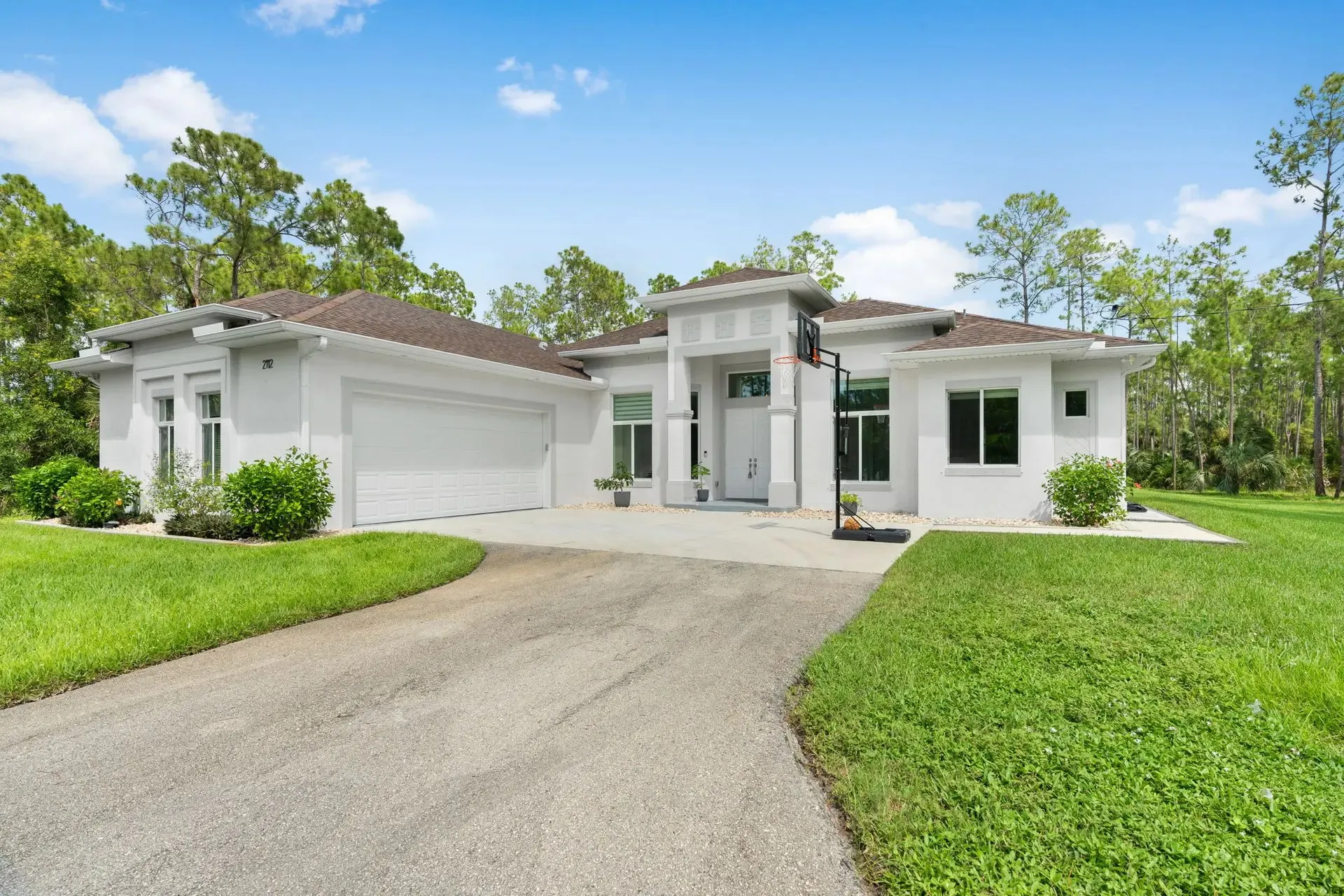 White single-story home with a wide lawn and driveway