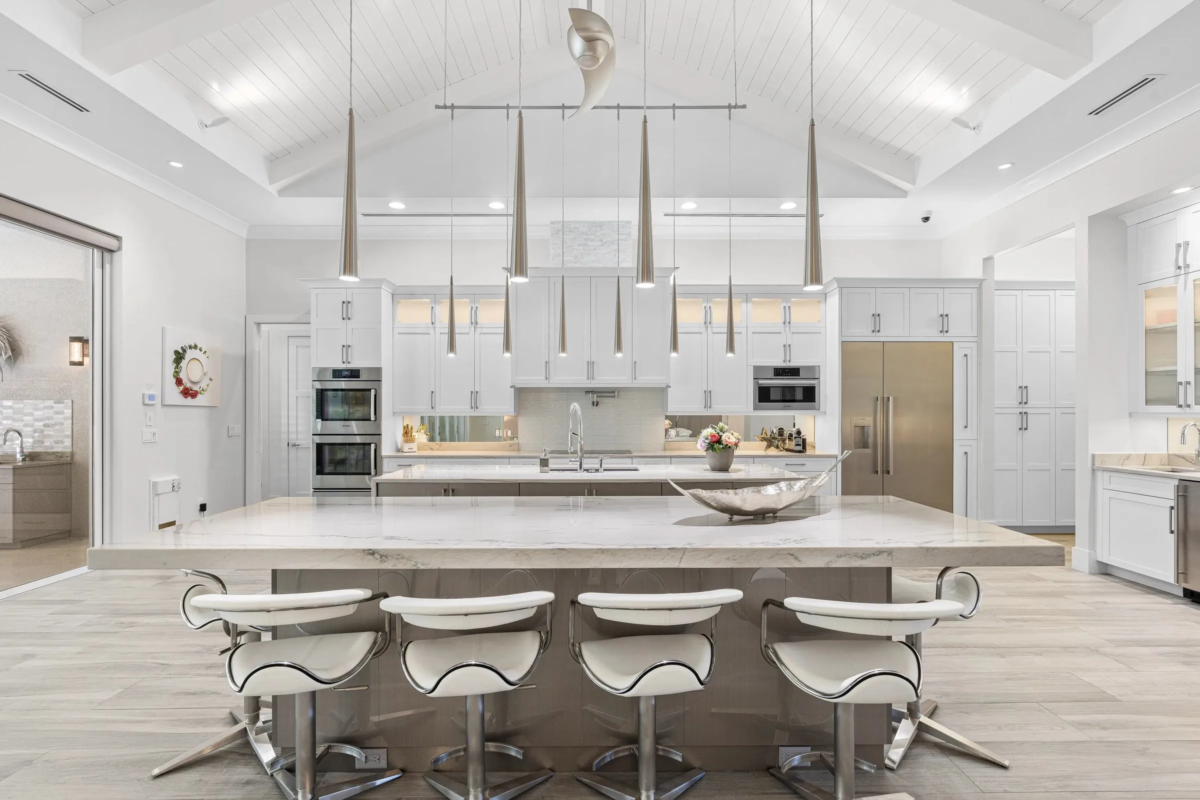 White kitchen with a large island and statement lighting