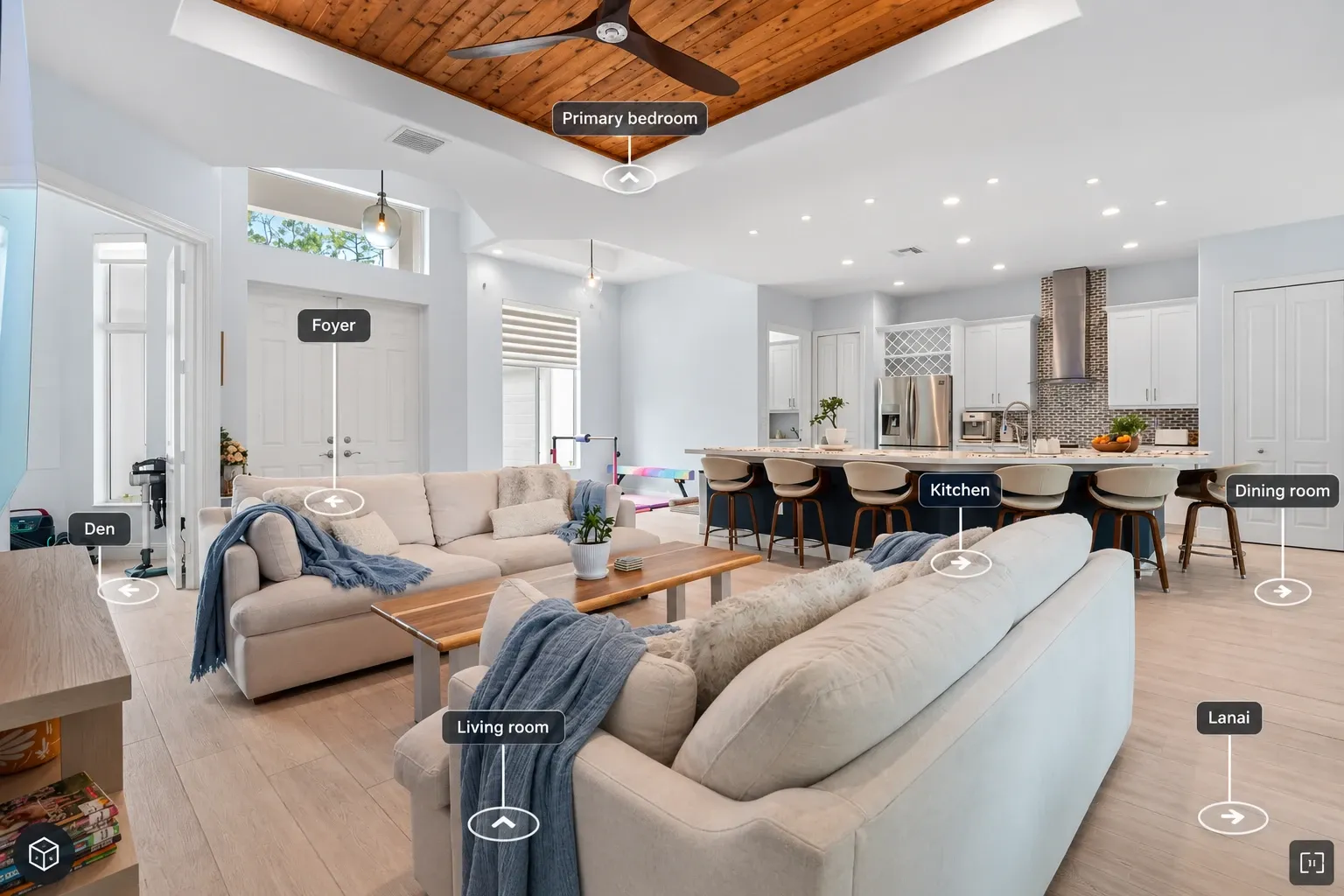 Zillow 3D Home tour of an open living room, with arrows to the kitchen, dining room, foyer and lanai